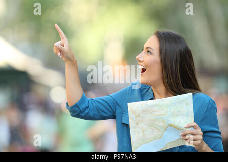 Felice azienda turistica una guida e puntando al lato su strada Foto Stock