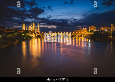 Bella Cattedrale Zaragosa in serata, Spagna. Punto di vista del ponte sul fiume Ebro Foto Stock
