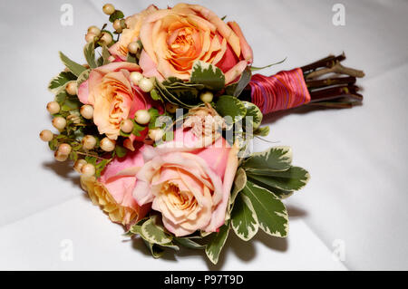 Un mazzo di fiori di nozze, rosa e arancio o pesca colorate di rose Foto Stock