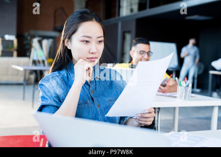 Giovane donna asiatica in un ufficio moderno Foto Stock