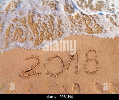 2018 Scritta sulla spiaggia sabbiosa nuovo anno sta arrivando come data di Concetto di vacanza Foto Stock
