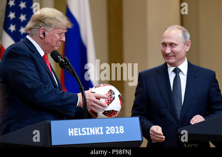 Helsinki, Finlandia. 16 Luglio, 2018. Stati Uniti Presidente Donald Trump (L) trattiene un pallone da calcio durante una conferenza stampa congiunta con il presidente russo Vladimir Putin a Helsinki in Finlandia, il 16 luglio 2018. Donald Trump e Vladimir Putin hanno iniziato il loro primo incontro bilaterale qui il lunedì. Credito: Lehtikuva/Antti Aimo-Koivisto/Xinhua/Alamy Live News Foto Stock