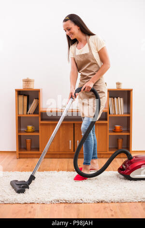 La pulizia della casa. Donna che utilizza un aspirapolvere. Foto Stock