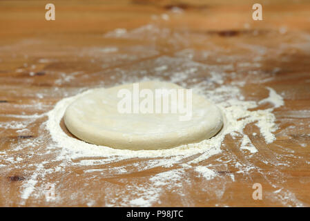 Impasto per pizza. Base per la cottura della pizza su una tavola di legno, close-up Foto Stock