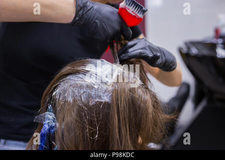 Parrucchiere professionale colorazione dei capelli della donna client presso studio Foto Stock