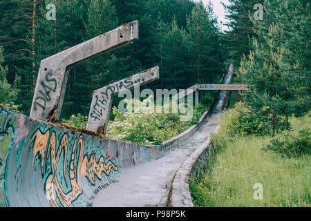 Ora il calcestruzzo in disuso del 1984 Sarajevo Olympic di bob e slittino curve traccia attraverso la foresta, coperto di graffiti Foto Stock