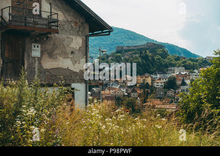 Una casa alla periferia di Jajce, con quello che sembra essere shrapnel danni all'esterno. La Fortezza Jajce si può vedere sulla collina dietro Foto Stock