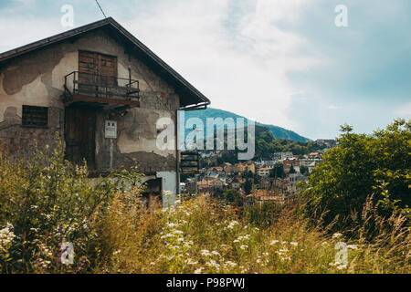 Una casa alla periferia di Jajce, con quello che sembra essere shrapnel danni all'esterno. La Fortezza Jajce si può vedere sulla collina dietro Foto Stock