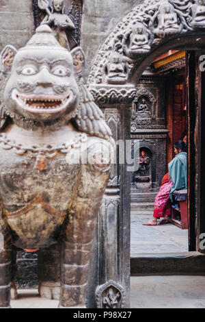 Lalitpur, Valle di Kathmandu, Nepal : donne siedono al cortile del XII secolo buddista di Tempio d'Oro (aka Kwa Bahal o Hiranya Varna Mahavihar) Foto Stock