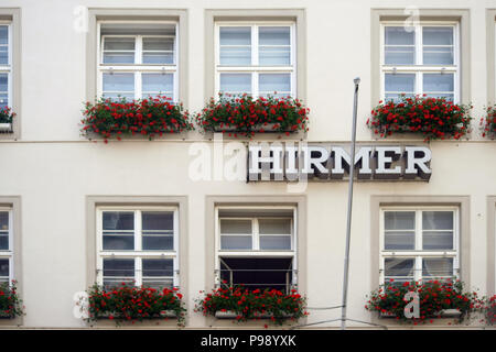 Monaco di Baviera, Germania - 30 Giugno 2018: la finestra facciata decorata con fioriere di uomini della casa di moda Hirmer sulla facciata esterna del dipartimento Foto Stock