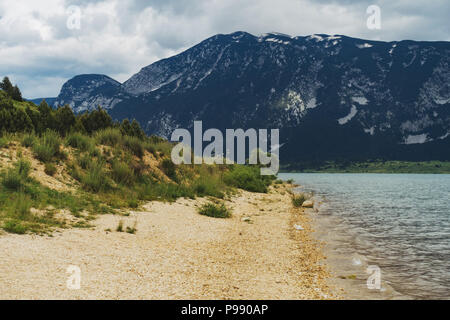 Un nuvoloso giorno accanto alle acque calme di Blidinje Jezero, il più grande lago della Bosnia ed Erzegovina Foto Stock