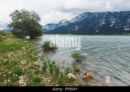 Un nuvoloso giorno accanto alle acque calme di Blidinje Jezero, il più grande lago della Bosnia ed Erzegovina Foto Stock