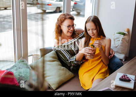 Bella ragazza adolescente appoggiata al suo felice madre Foto Stock