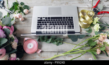 Il concetto di ordine di prelievo e consegna. tavolo di lavoro in negozio di fiori. Ragazza assistant o il proprietario in floral design studio, rendendo le decorazioni e le modalità. Foto Stock