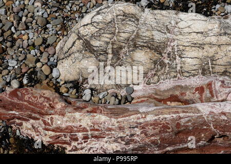 Calcite e rosso ematite associati con idro soluzioni termiche dal vecchio sottostante di sabbia rossa sulla pietra Mumbles testa & minata dai romani Foto Stock