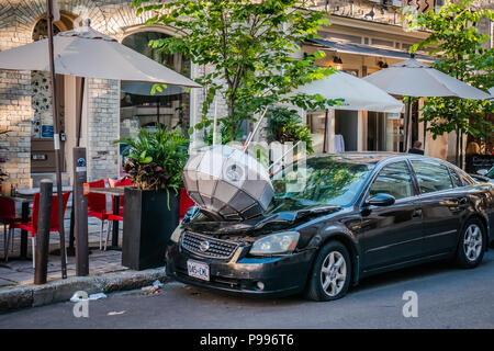 Un oggetto di argento danneggiato la parte anteriore di un auto nera Foto Stock