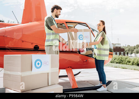 Accattivante due volontari fornendo aiuti Foto Stock