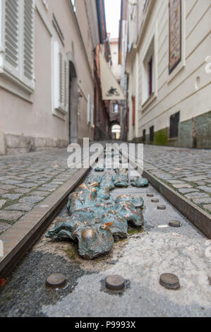 Una installazione di bronzo di facce da artista Jakov Brdar ispirato da un pezzo dallo scrittore R M Rilke, su Kljucavnicarska ulica (Fabbro Street), Ljubljana. Foto Stock