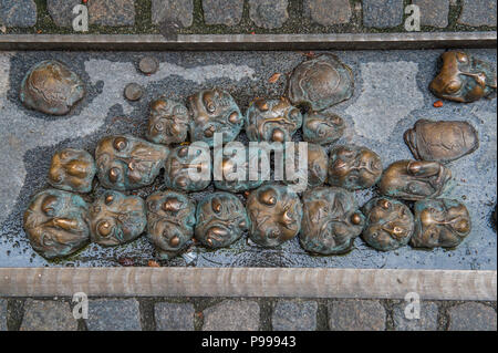 Una installazione di bronzo di facce da artista Jakov Brdar ispirato da un pezzo dallo scrittore R M Rilke, su Kljucavnicarska ulica (Fabbro Street), Ljubljana. Foto Stock