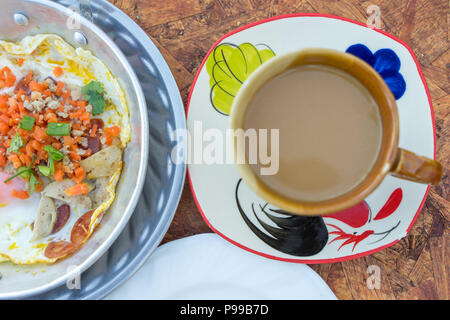 Nord-est colazione tailandese con caffè, padella calda uovo fritto farcite con carne macinata di maiale e salsiccia, comuni anche per il vietnamita e il Laos persone Foto Stock