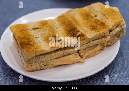 Tradizionale colazione Singapore chiamato Kaya toast, pane di cocco con marmellata e burro, il fuoco selettivo tecnica Foto Stock