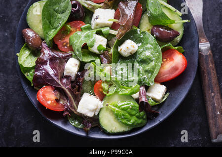 Il greco feta e olive con insalata di pomodori, cetrioli e vinaigrette dressing Foto Stock