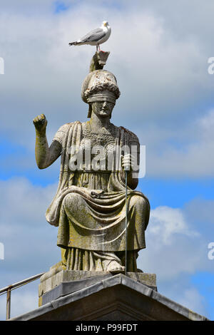 Vista della Britannia statua sulla sommità del Municipio in Castello di Fossato da Caernarfon Castle, Caernarfon Galles del Nord Foto Stock