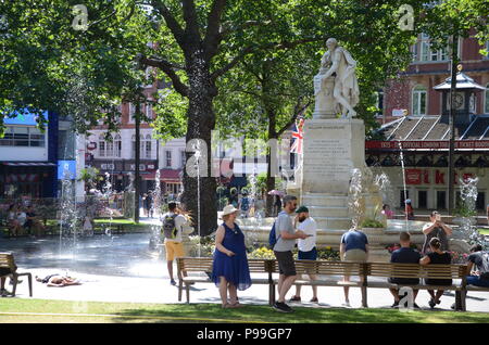 Una donna senzatetto passata fuori in leicester square gardens Londra con i turisti 2018 Foto Stock