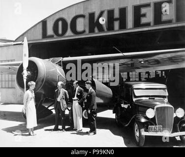 Amelia Earhart con Allen Lockheed, Carl Squier e Floyd vapore a Lockheed di hangar di Burbank, in California, in piedi accanto al Lockheed Vega 5B in cui Earhart divenne la prima donna a completare un solo volo transatlantico del 21 maggio 1932. (Foto: 1932) Foto Stock