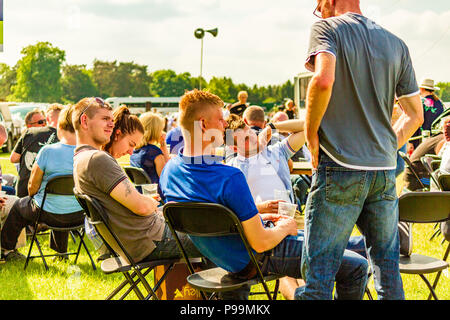 Un gruppo di giovani uomini di bere fuori sotto il sole presso la contea di Northumberland Show, maggio 2018. Foto Stock