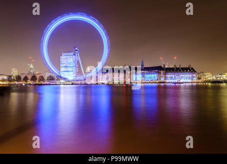 Esposizione lunga notte tempo vista la Coca-Cola London Eye e County Hall da Embankment, Londra, riflesso nel Tamigi, illuminato contro un cielo chiaro Foto Stock