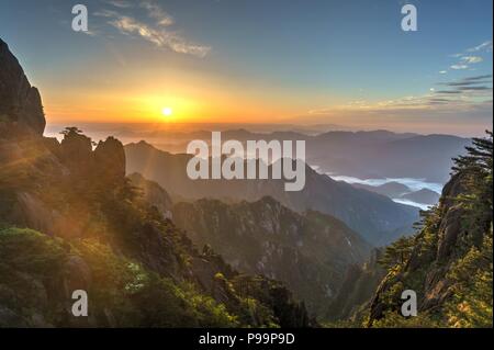Colorato tramonto sul mare di nuvole a uno dei picchi di Huangshan mountain range nel sud della provincia di Anhui in Cina orientale. Foto Stock