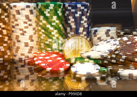 Golden bitcoin davanti a pile di bianco verde blu e rosso fiches ingrandita nella moneta in medio Foto Stock