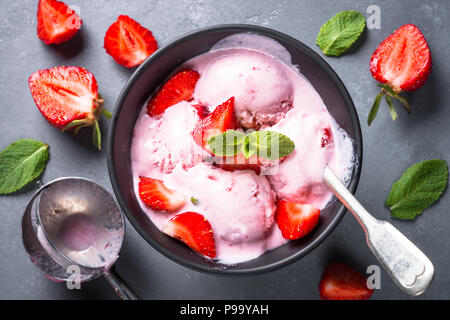 Gelato alla fragola con frutti di bosco freschi in una ciotola in pietra grigia tabella. Vista da sopra con copia spazio. Foto Stock