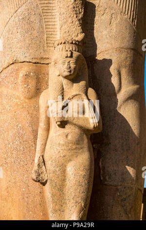 Dettaglio della statua colossale e figura in miniatura della moglie di Pinedjem I, Sommo Sacerdote di Amon, secondo pilone, Tempio di Karnak. Luxor, Egitto, Africa Foto Stock