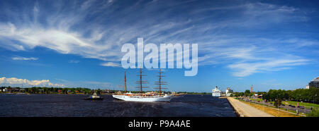 Panorama del porto di Riga sul fiume Daugava con un tre-masted in barca a vela e un traghetto passeggeri in mezzo a bellissimi nuvole su un Cielo di estate blu... Foto Stock