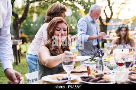 Gli ospiti di mangiare al ricevimento di nozze al di fuori nel cortile. Foto Stock