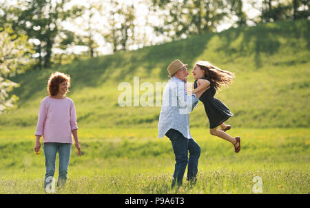 Coppia senior con il nipote fuori in primavera la natura, divertendosi. Foto Stock