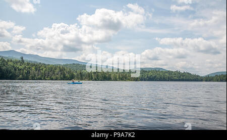 Kayaker femmina su un laghetto remoto nel deserto Adirondack Foto Stock