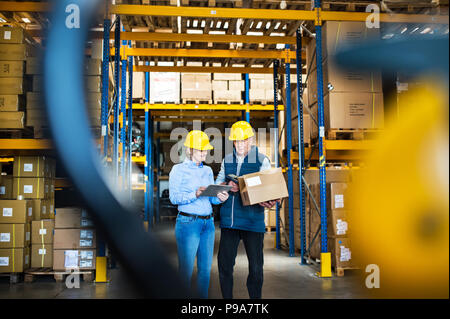 Senior manager o supervisori con la compressa a lavorare in un magazzino, il controllo di magazzino. Foto Stock