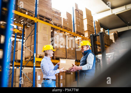 Senior manager o supervisori lavorano insieme in un magazzino. Foto Stock