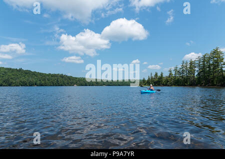 Kayaker femmina su un laghetto remoto nel deserto Adirondack Foto Stock