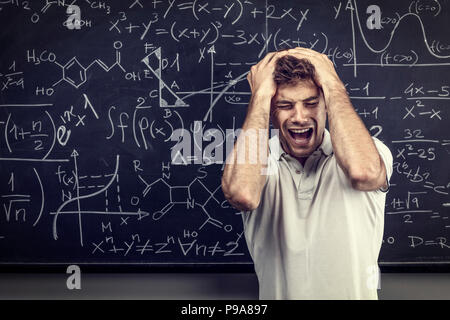 Sottolineato insegnante urlare e tenere la sua testa Foto Stock