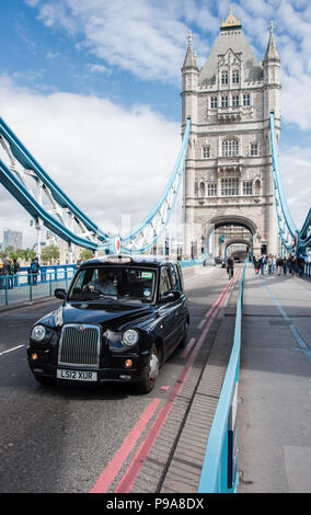 Testa sulla visualizzazione verticale di una Londra taxi nero che viaggiano attraverso il Tower Bridge con assenza di congestione del traffico Foto Stock