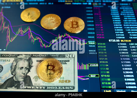 La carta bill venti Dollar, USD, sfondo sfocato. Il programma elettronico di bitcoin sullo scambio, volume trades, sul monitor si trovano monete d oro bitcoin. Foto Stock