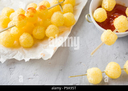 Formaggio palline di mais con il piccante salsa di pomodoro. Foto Stock