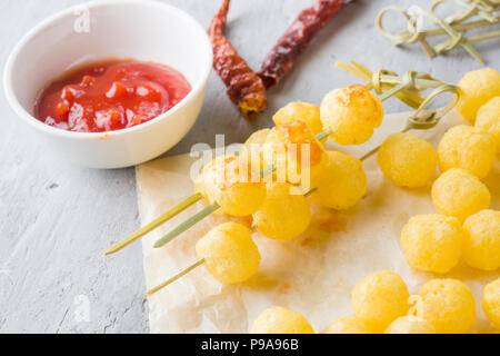 Formaggio palline di mais con il piccante salsa di pomodoro. Foto Stock