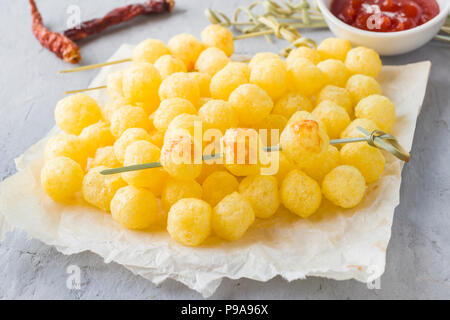 Formaggio palline di mais con il piccante salsa di pomodoro. Foto Stock