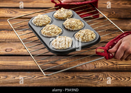 Tortini di carote con limone e apple, mandorle su sfondo di legno, materie prime sotto forma di silicone su una placca da forno Foto Stock