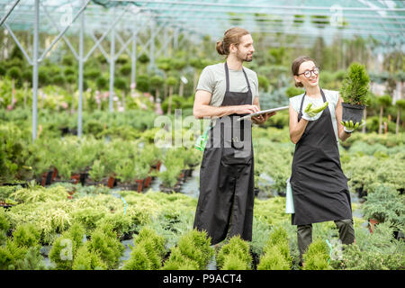 I lavoratori con la compressa nella serra Foto Stock